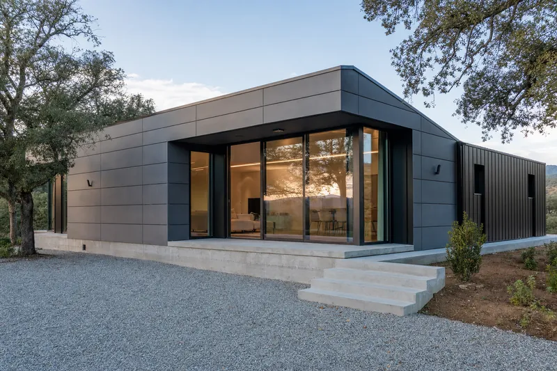 86 m² three-bedroom prefabricated modular house in dark grey panels with glazed corner